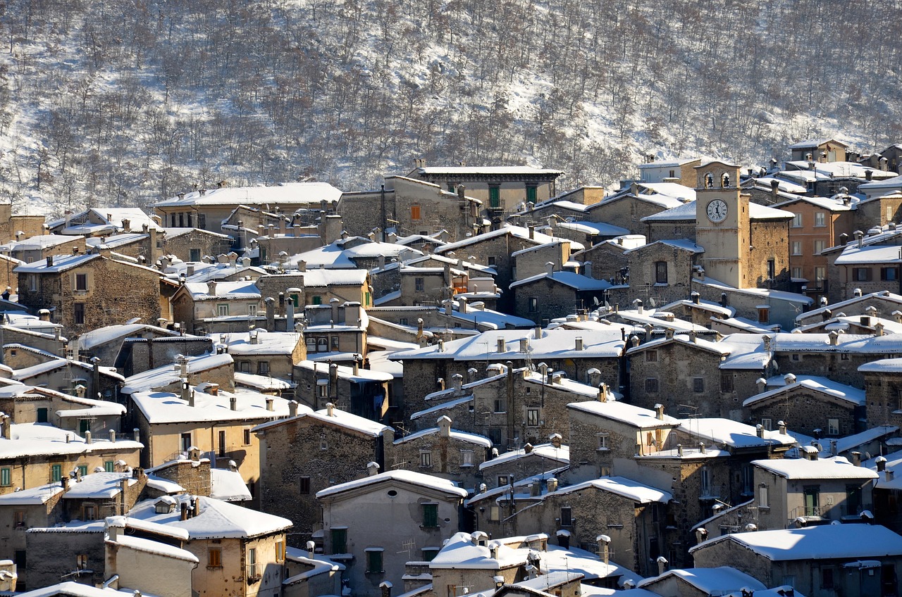 Panorama di Aosta in primavera, con fiori che sbocciano e montagne innevate sullo sfondo.